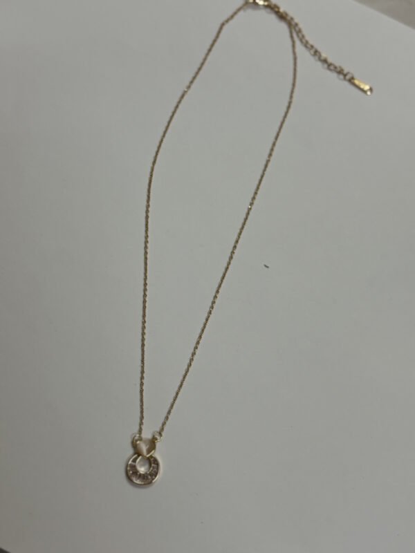 Studio shot of Lumina gold heart pendant necklace on marble stone