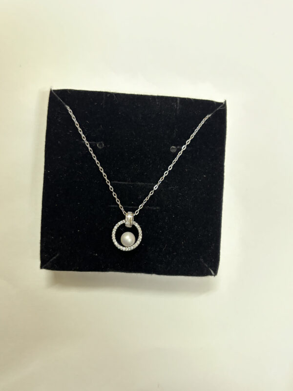 Detailed view of pearl pendant necklace on satin silk
