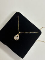 Front view of elegant gold plated pendant necklace with sparkling stone