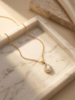 Lumina Gold Plated Pendant Necklace on a desert-inspired stone display