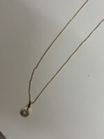 Lumina Gold Plated Pendant Necklace on a desert-inspired stone display