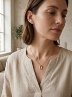 Close up of the Lumina Teardrop Golden Necklace on a white background