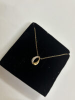 Close up of the Lumina Teardrop Golden Necklace on a white background