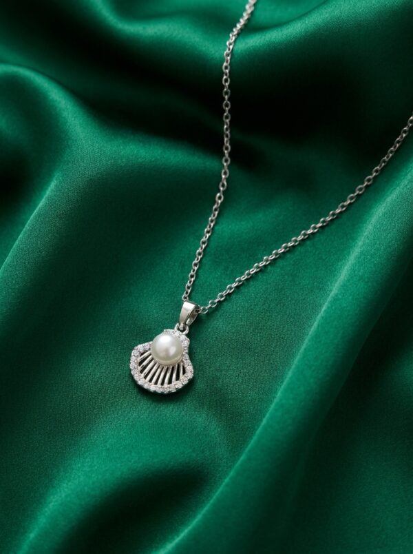 A close-up of the Pearl Shell Pendant Necklace on a black velvet box