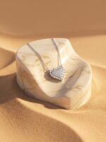 Close up of silver heart necklace on black velvet box