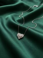 Close up of silver heart necklace on black velvet box