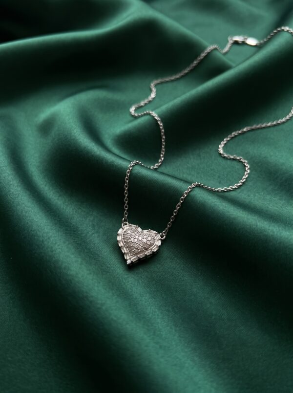 Close up of silver heart necklace on black velvet box