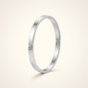 Minimalist silver cuff bracelet resting on stones