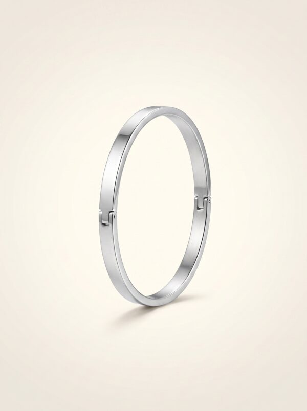 Minimalist silver cuff bracelet resting on stones