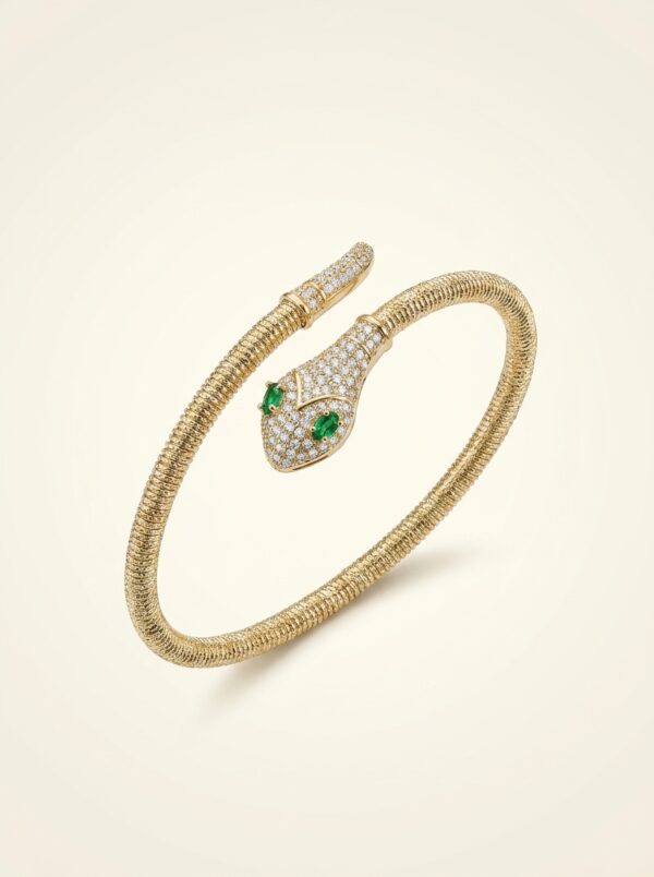 Close up of gold plated coiled snake bracelet with green stones