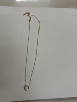 Close up of the round pendant with pave details on a velvet stand