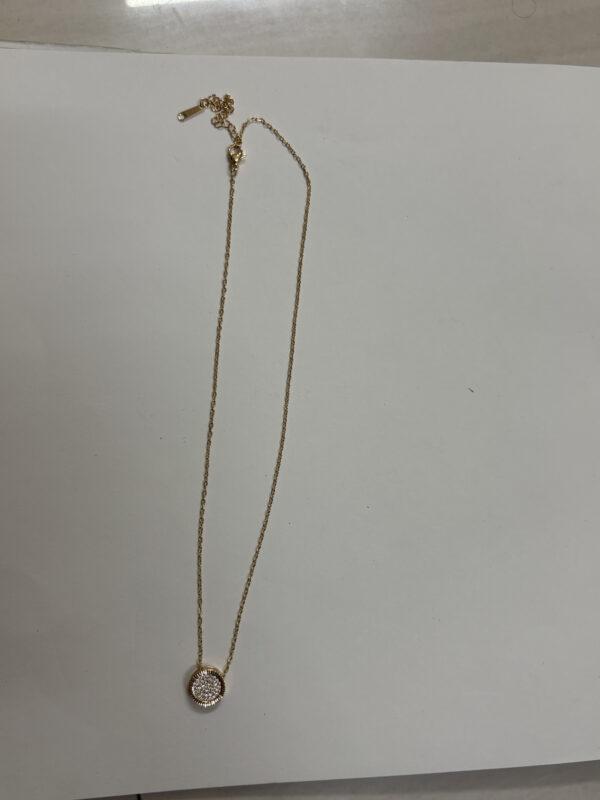 Close up of the round pendant with pave details on a velvet stand