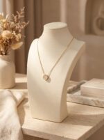 Full shot of the delicate gold chain necklace with a circular paved pendant