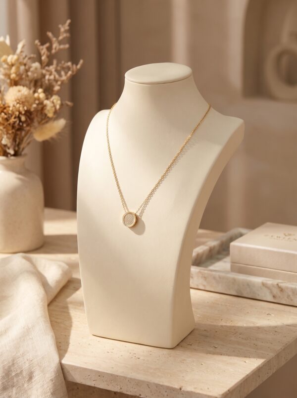 Full shot of the delicate gold chain necklace with a circular paved pendant