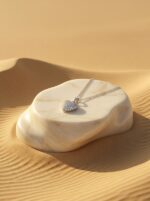 Starlight Paved Heart Necklace on desert-inspired podium