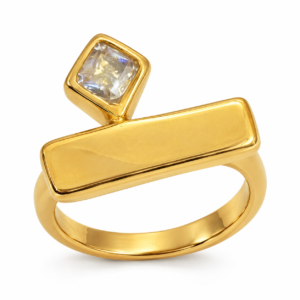 A minimalist gold ring featuring a geometric bar and square stone on a clean white background