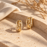 A pair of gold-plated Aura Geometric Hoop Earrings featuring intricate lattice work and sparkling stones