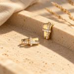 A pair of gold plated studs with interlinked design and white stones