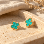 Pair of turquoise clover gold plated earrings on white background