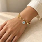 A model wearing a dainty gold plated evil eye bracelet with celestial charms