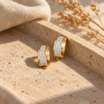 Pair of gold Lumina Crystal Hoop Earrings on white background