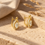 Pair of gold plated earrings with oval centerpiece and halo of crystals