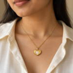 A model wearing the gold pearl heart necklace on a white shirt