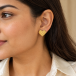 Model wearing elegant gold heart studs on earlobe