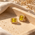 A pair of gold-plated Yellow Stone Studs featuring a radiant rectangular yellow stone surrounded by a crystal halo